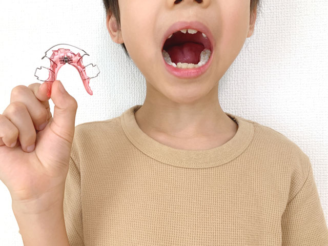 歯の矯正器具と子ども